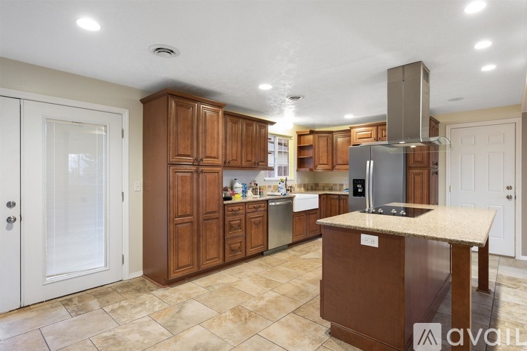 A kitchen with wooden cabinets and a granite countertop.