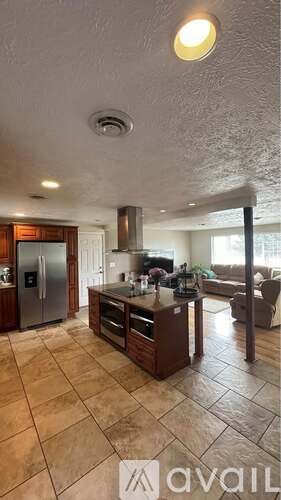A kitchen with tile flooring and a refrigerator.