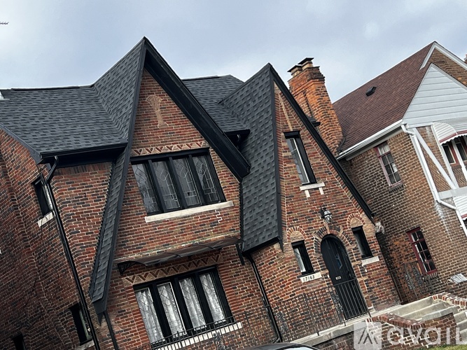 A red brick house with a black roof.