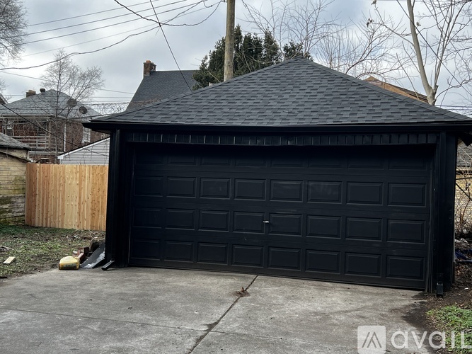 A black garage door is closed and the garage is attached to a house.