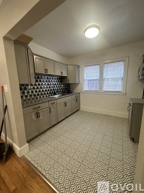 A kitchen with a tile floor and a window.