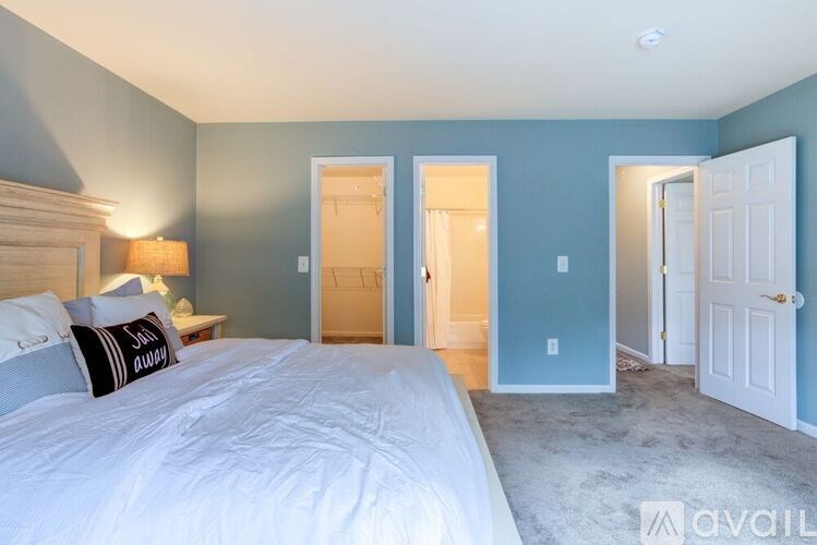 A bedroom with a large bed and a carpeted floor.