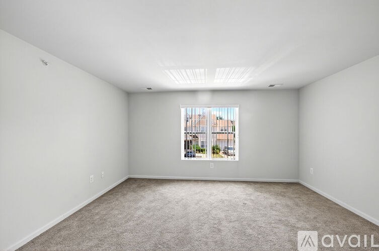 A spacious empty room with a window showing a cityscape.