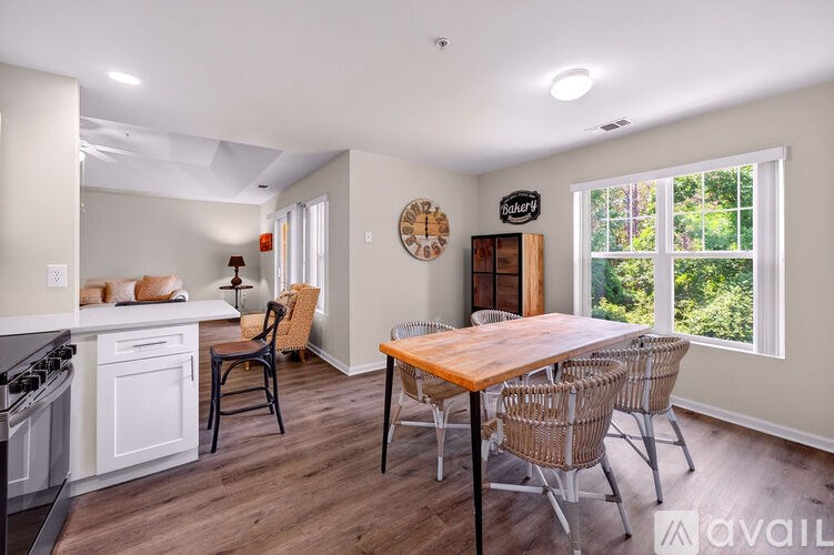 A kitchen with a table and chairs in front of a window.
