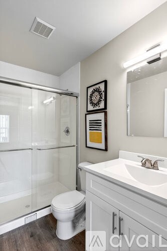 A bathroom with a toilet, sink, and shower.