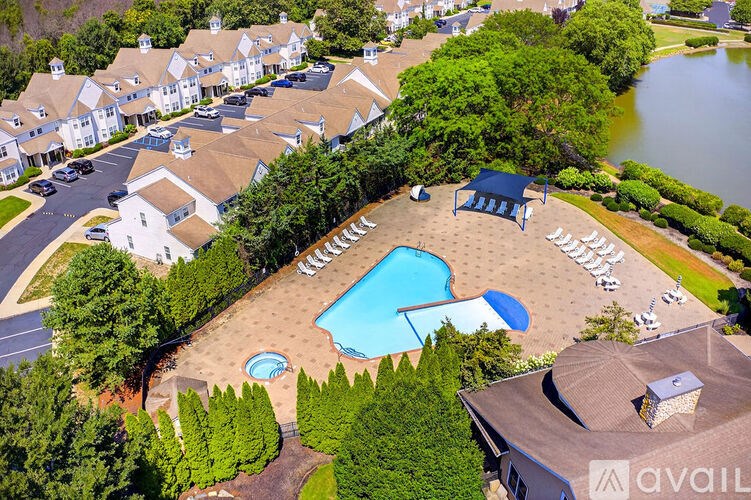 A bird's eye view of a resort with a swimming pool and a lake.