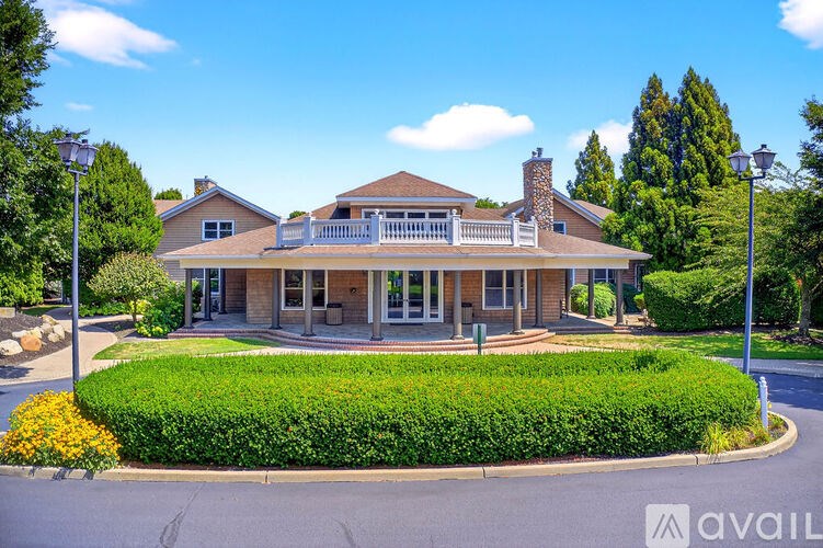 A house with a well-manicured lawn and a clear blue sky above.