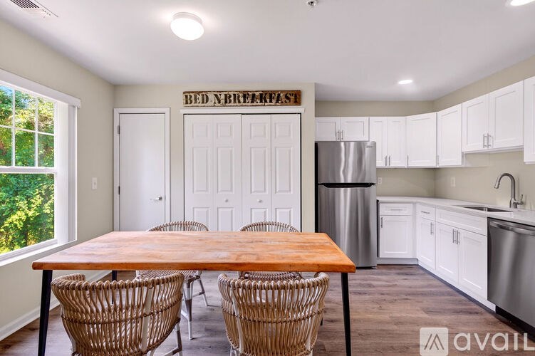 A kitchen with a table and chairs in front of a refrigerator.
