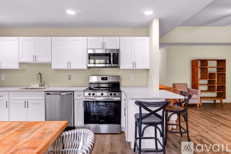 A kitchen with white cabinets and a wooden table.