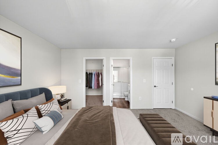 A bedroom with a large bed and a painting on the wall.
