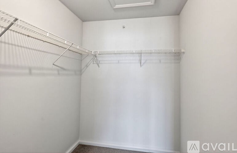 A white closet with a metal rod for hanging clothes.