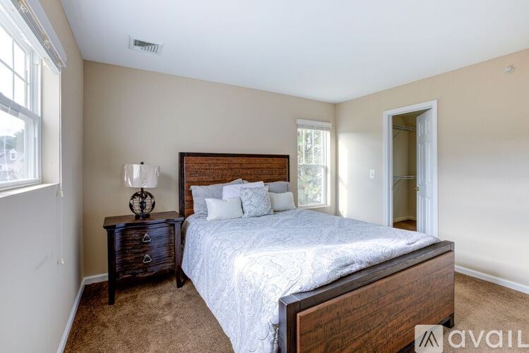 A bedroom with a bed, nightstand, and window.