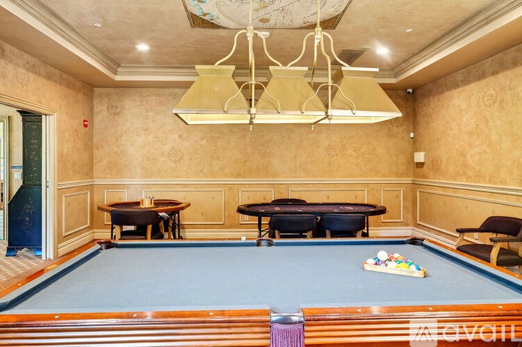 A pool table in a room with a chandelier.