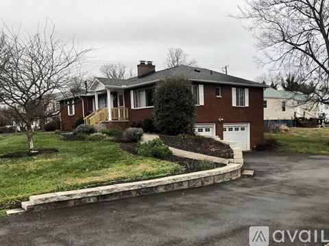 A house with a brick facade and a white garage door is available for sale.
