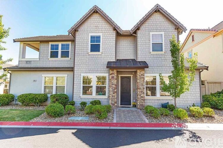 A two-story house with a front yard and a driveway.