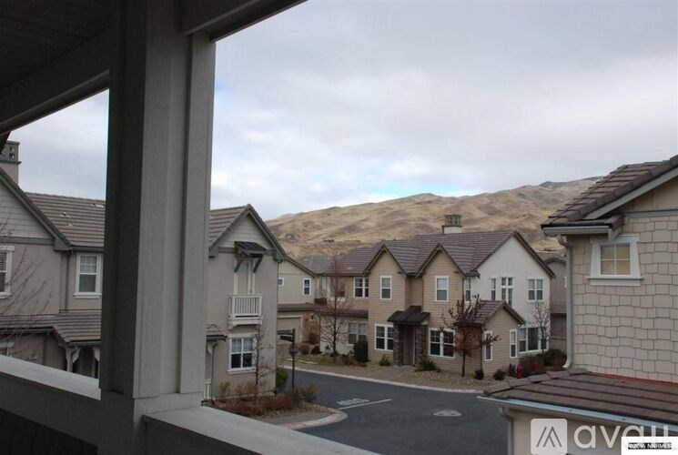 A view of a residential area with houses and a mountain in the background.