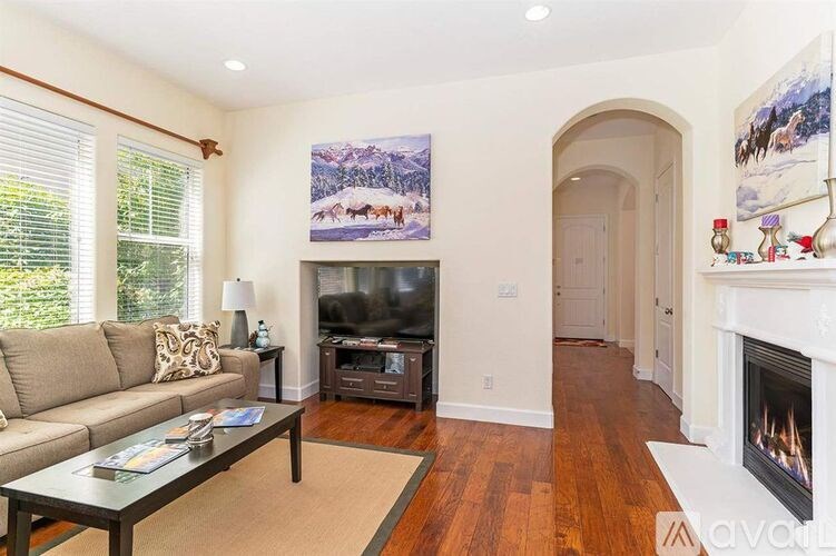 A living room with a couch, coffee table, and a fireplace.