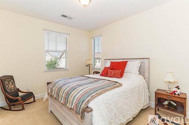 A bedroom with a large bed and a chair.