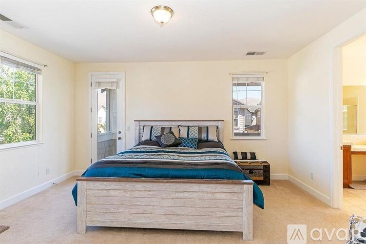A bedroom with a bed, nightstand, and window.