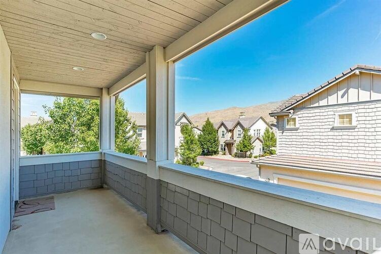 A balcony with a view of houses and trees.