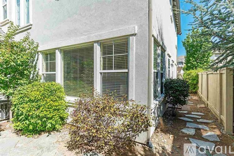 A house with a garden in front of it is for sale.