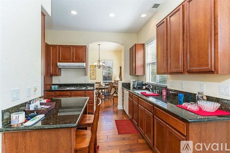 A kitchen with wooden cabinets and a black countertop.