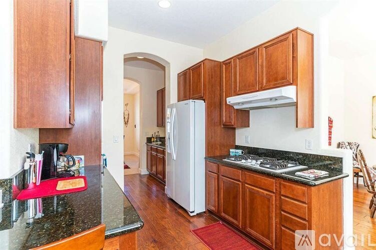 A kitchen with wooden cabinets and a black granite countertop.