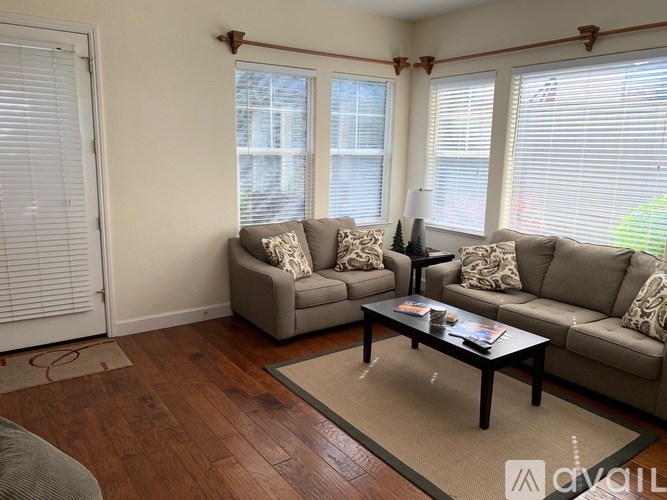 A living room with two grey couches and a coffee table.