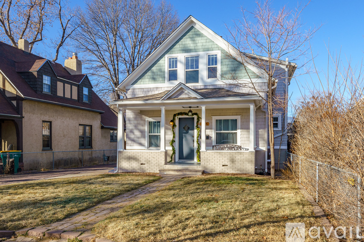 A house with a green lawn in front of it.