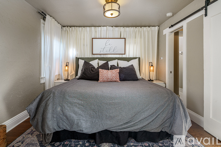 A bedroom with a bed, pillows, and a sign that says "Lee".