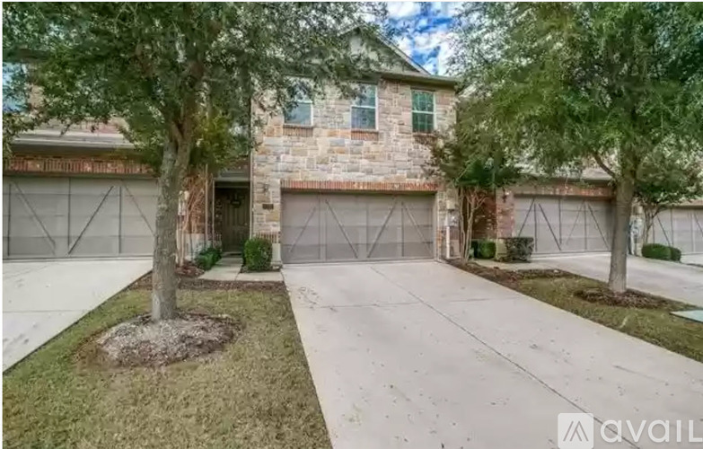 A house with a stone exterior and a large driveway.