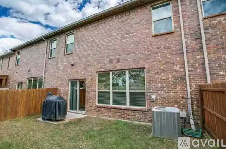 A brick house with a green lawn in front.