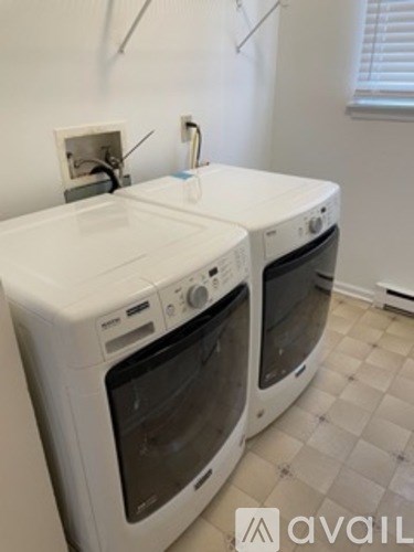 Two white ovens in a kitchen with a tiled floor.
