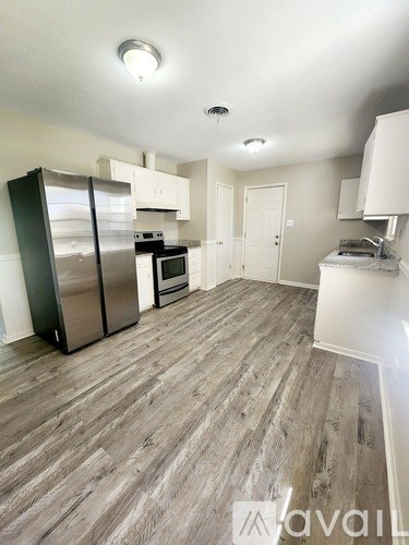 A kitchen with a refrigerator, oven, and microwave.