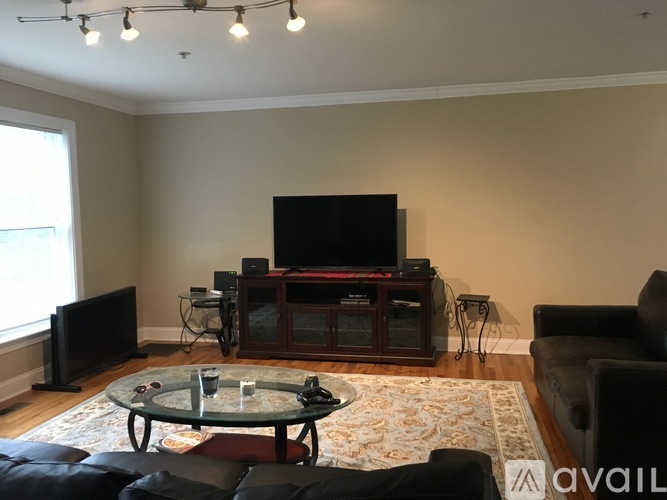 A living room with a glass coffee table and a television.