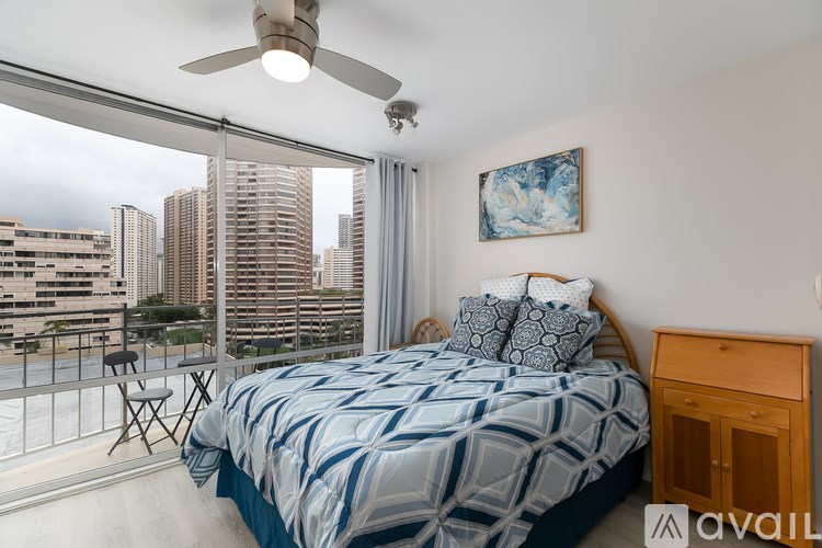 A bedroom with a large bed and a balcony overlooking a cityscape.