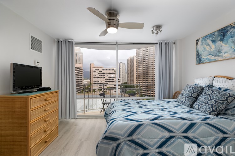 A bedroom with a large bed and a television on a wooden dresser.