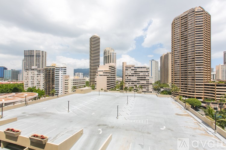 A parking lot with a view of a city skyline in the background.