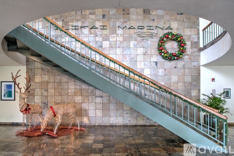 A wreath hangs on a wall above a staircase.