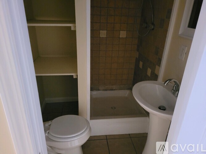 A bathroom with a toilet, sink, and shower.