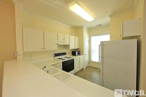 A kitchen with white cabinets and appliances.