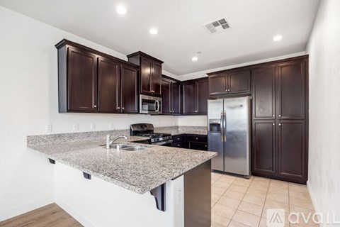 A kitchen with brown cabinets and a granite countertop.