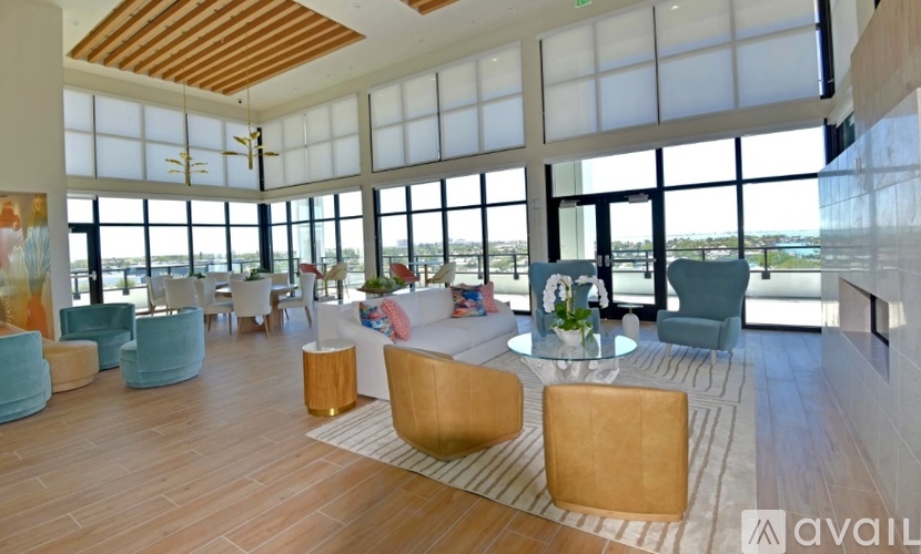 A living room with a wooden floor and a large window overlooking the water.