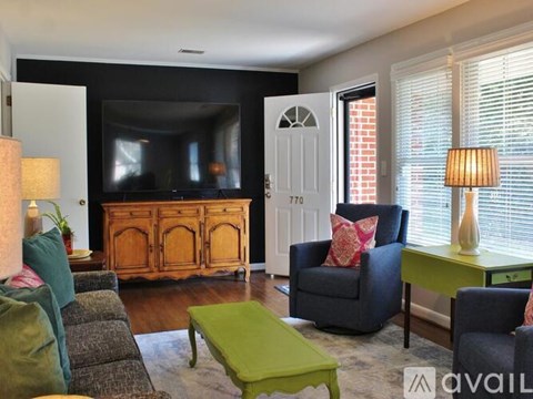 A living room with a green coffee table and a grey couch.