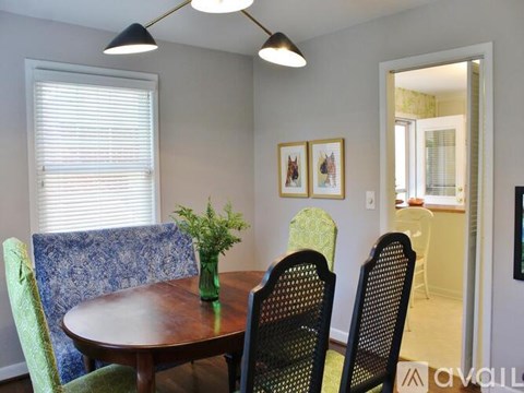 A dining room with a table and chairs.