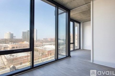 A room with a view of the city through large windows.