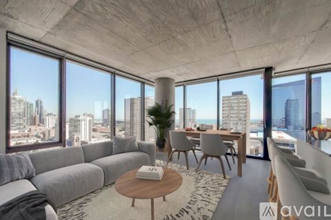 A modern living room with a large grey sofa and a view of the city.