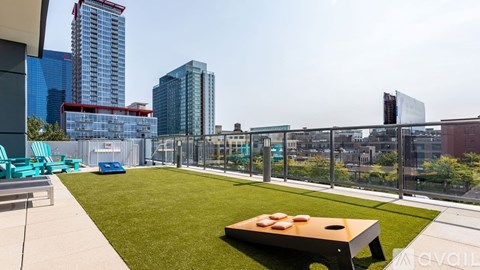 A rooftop patio with a table and chairs overlooking a city skyline.