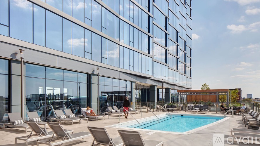 A large glass building with a pool in front.