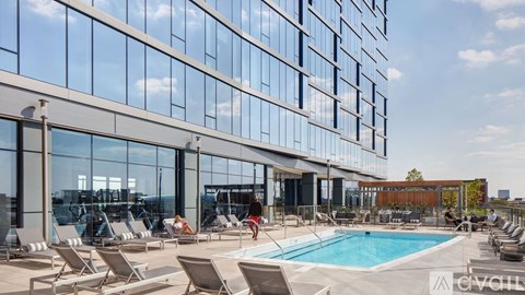 A large glass building with a pool in front.
